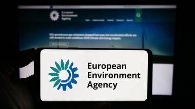 Stuttgart, Almanya - 10-25-2023: İnternet sayfası önünde AB enstitüsü Avrupa Çevre Ajansı 'nın (AÇA) logosuyla cep telefonu tutan kişi. Telefon ekranına odaklan.