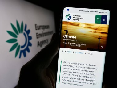 Stuttgart, Almanya - 10-25-2023: Logo önünde AB kurumu Avrupa Çevre Ajansı (AÇA) web sayfası bulunan kişi. Telefon ekranının merkezine odaklan.