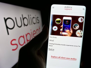 Stuttgart, Almanya - 10-28-2023: Dijital danışmanlık şirketi Publicis Sapient 'in internet sayfası olan akıllı telefonu logo önünde tutan kişi. Telefon ekranının merkezine odaklan.
