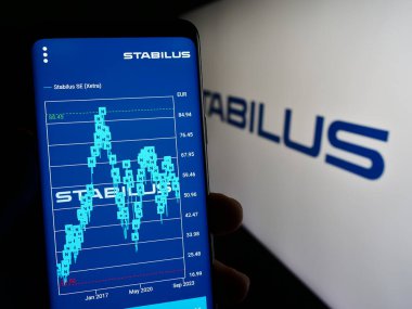 Stuttgart, Almanya - 10-29-2023: Alman hareket kontrol şirketi Stabilus SE 'nin internet sayfası ile logo önünde cep telefonu tutan kişi. Telefon ekranının merkezine odaklan.