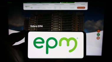 Stuttgart, Almanya - 10-29-2023: Sitenin önünde Kolombiyalı Empresas Publicas de Medellin (EPM) şirketinin logosuna sahip kişi. Telefon ekranına odaklan.