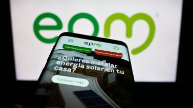 Stuttgart, Almanya - 10-29-2023: İş logosu önünde Kolombiyalı Empresas Publicas de Medellin (EPM) şirketinin web sitesi ile cep telefonu. Telefon ekranının sol üst kısmına odaklan.