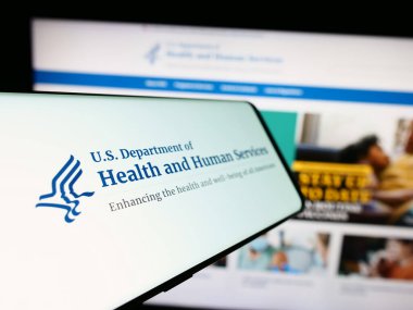 Stuttgart, Almanya - 10-29-2023: İnternet sitesi önünde Amerikan Sağlık ve İnsani Hizmetler Dairesi (HHS) logosu bulunan cep telefonu. Telefon ekranının merkez soluna odaklan.