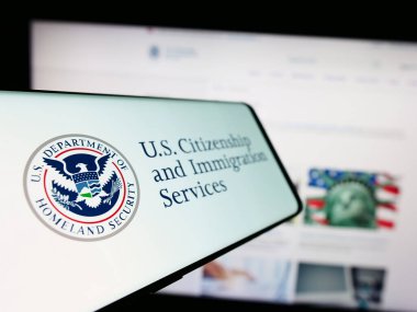 Stuttgart, Almanya - 10-29-2023: İnternet sitesi önünde Amerikan Vatandaşlık ve Göçmenlik Hizmetleri (USCIS) mührü bulunan cep telefonu. Telefon ekranının soluna odaklan.