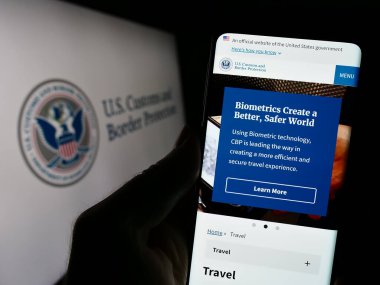 Stuttgart, Almanya - 10-29-2023: ABD Gümrük ve Sınır Koruma Dairesi 'nin (CBP) mühürlü web sayfası ile cep telefonu tutan kişi. Telefon ekranının merkezine odaklan.