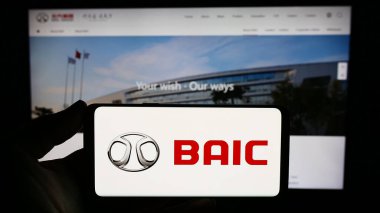 Stuttgart, Almanya - 10-30-2023: Çinli şirket Beijing Automotive Group Co. Ltd. (BAIC) 'nin logosuna sahip kişi web sitesinin önünde. Telefon ekranına odaklan.