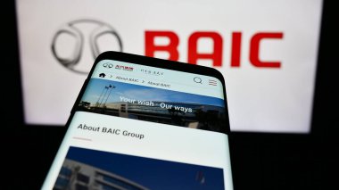 Stuttgart, Almanya - 10-30-2023: Çinli şirket Beijing Automotive Group Co. Ltd. (BAIC) 'nin web sitesiyle birlikte logo önünde cep telefonu. Telefon ekranının merkezine odaklan.