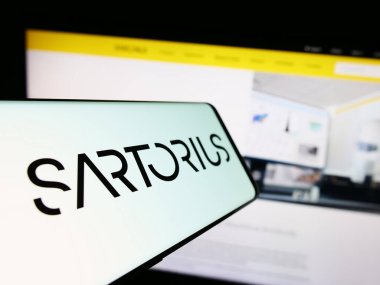 Stuttgart, Almanya - 09-10-2023: Alman ilaç firması Sartorius AG 'nin logosunun yer aldığı cep telefonu iş sitesinin önünde ekranda. Telefon ekranının merkez soluna odaklan.