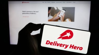 Stuttgart, Almanya - 09-11-2023: Alman gıda sipariş şirketi Delivery Hero SE 'nin logosunun bulunduğu cep telefonu web sayfası önünde ekranda. Telefon ekranına odaklan.