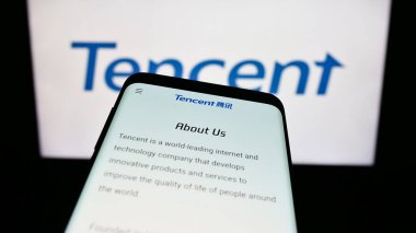 Stuttgart, Almanya - 09-11-2023: Çinli şirket Tencent Holding Ltd. 'nin web sitesi olan akıllı telefon iş logosu önünde ekranda. Telefon ekranının sol üst kısmına odaklan.