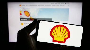 Stuttgart, Almanya - 09-11-2023: İngiliz petrol ve doğalgaz şirketi Shell plc 'nin logosunun bulunduğu cep telefonu sahibi kişi iş sayfasının önünde ekranda. Telefon ekranına odaklan.