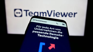 Stuttgart, Almanya - 09-13-2023: Alman yazılım şirketi TeamViewer SE 'nin web sitesi ile cep telefonu iş logosu önünde ekranda. Telefon ekranının sol üst kısmına odaklan.