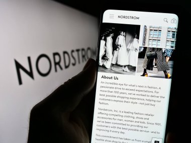 Stuttgart, Almanya - 09-13-2023: ABD 'li mağaza şirketi Nordstrom Inc.' nin web sayfası ile cep telefonu elinde tutan kişi logo önünde ekranda. Telefon ekranının merkezine odaklan.