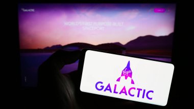 Stuttgart, Almanya - 09-13-2023: Web sitesi önünde ekranda ABD 'li uzay aracı şirketi Virgin Galactic' in logosunu taşıyan kişi. Telefon ekranına odaklan.