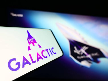 Stuttgart, Germany - 09-13-2023: Smartphone with logo of American spaceflight company Virgin Galactic on screen in front of website. Focus on center-left of phone display. clipart