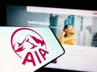 Stuttgart, Almanya - 09-13-2023: Sigorta şirketi AIA Group Limited 'in logosuna sahip cep telefonu iş sitesinin önünde ekranda. Telefon ekranının merkez sağına odaklan.