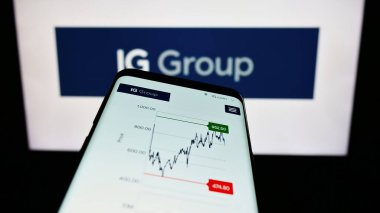 Stuttgart, Almanya - 09-14-2023: İngiliz ticaret şirketi IG Group Holding 'in web sitesi bulunan cep telefonu logonun önünde ekranda. Telefon ekranının sol üst kısmına odaklan.