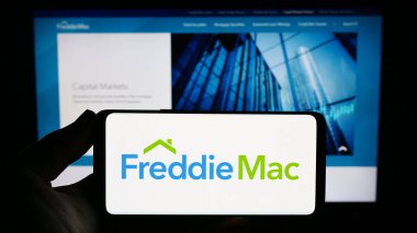 Stuttgart, Almanya - 09-17-2023: ABD 'li ipotek şirketi Freddie Mac' in logosunu elinde tutan kişi web sitesinin önünde ekranda. Telefon ekranına odaklan.
