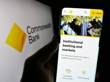 Stuttgart, Almanya - 09-17-2023: Commonwealth Bank of Australia (CBA) adlı şirketin internet sayfası ile ekranda bulunan kişi. Telefon ekranının merkezine odaklan.