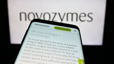 Stuttgart, Almanya - 09-17-2023: Danimarkalı biyoteknoloji şirketi Novozymes AS 'in web sitesi ile cep telefonu iş logosu önünde ekranda. Telefon ekranının sol üst kısmına odaklan.