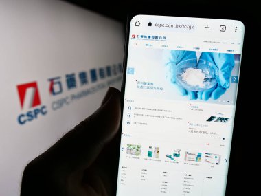 Stuttgart, Almanya - 09-17-2023: CSPC Pharmaceutical Group Limited şirketinin web sayfasını elinde tutan kişi logo ile ekranda. Telefon ekranının merkezine odaklan.