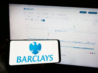 Stuttgart, Almanya - 09-18-2023: İngiliz evrensel bankası Barclays plc logosu olan cep telefonu sahibi kişi şirket web sayfasının önünde ekranda. Telefon ekranına odaklan.