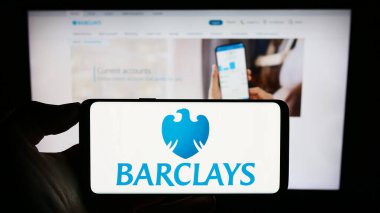 Stuttgart, Almanya - 09-18-2023: İngiliz evrensel bankası Barclays plc logosu olan cep telefonu sahibi kişi iş sayfasının önünde ekranda. Telefon ekranına odaklan.