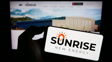 Stuttgart, Almanya - 09-20-2023: Çinli şirket Sunrise New Energy Co. Ltd. nin logosuyla cep telefonu sahibi kişi iş sayfasının önünde ekranda. Telefon ekranına odaklan.