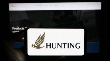 Stuttgart, Almanya - 09-20-2023: İngiliz enerji teknoloji şirketi Hunting plc 'nin logosunun bulunduğu cep telefonu web sayfasının önünde ekranda. Telefon ekranına odaklan.
