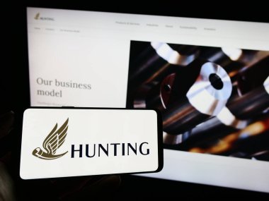 Stuttgart, Almanya - 09-20-2023: İngiliz enerji teknoloji şirketi Hunting plc 'nin logosunun bulunduğu cep telefonu web sayfası önünde ekranda. Telefon ekranına odaklan.