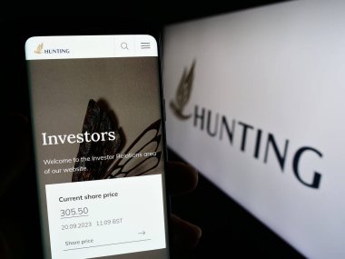 Stuttgart, Almanya - 09-20-2023: İngiliz enerji teknolojisi şirketi Hunting plc 'nin web sayfası ve logosu olan kişi. Telefon ekranının merkezine odaklan.