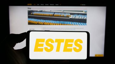 Stuttgart, Almanya - 09-20-2023: Amerikan lojistik şirketi Estes Express Lines 'in logosuna sahip cep telefonu sahibi kişi web sayfasının önünde ekranda. Telefon ekranına odaklan.