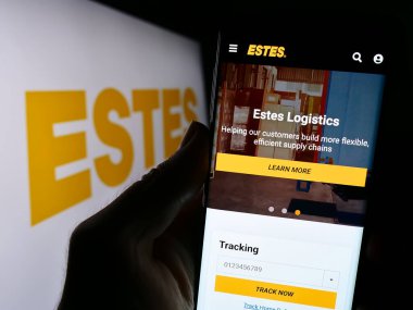 Stuttgart, Almanya - 09-20-2023: ABD 'li lojistik şirketi Estes Express Lines' in web sitesi ile cep telefonu tutan kişi logo önünde ekranda görülüyor. Telefon ekranının merkezine odaklan.