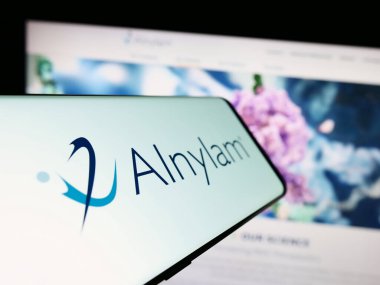 Stuttgart, Almanya - 09-20-2023: İnternet sitesinin önünde ekranda Alnylam Pharmaceuticals Inc. 'in logosu olan cep telefonu. Telefon ekranının merkez soluna odaklan.
