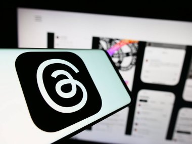 Stuttgart, Almanya - 09-21-2023: Sosyal ağ başlıkları logosuna sahip cep telefonu (Meta Platformları Inc.) iş dünyasının web sitesi önünde ekranda. Telefon ekranının merkezine odaklan.