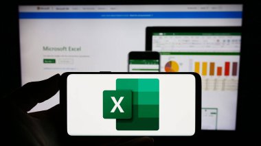 Stuttgart, Almanya - 09-21-2023: İnternet sitesinin önünde ekranda hesap çizelgesi editörü Microsoft Excel 'in logosuna sahip akıllı telefonu tutan kişi. Telefon ekranına odaklan.