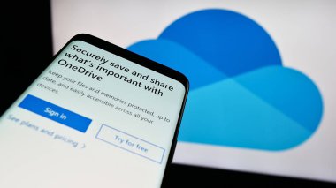 Stuttgart, Almanya - 09-21-2023: Dosya sunucu servisi Microsoft OneDrive 'ın web sitesi ile cep telefonu iş logosu önünde ekranda. Telefon ekranının sol üst kısmına odaklan.