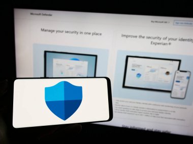 Stuttgart, Almanya - 09-21-2023: Güvenlik yazılımı logosu olan cep telefonu sahibi kişi Microsoft Defender Antivirus web sayfası önünde ekranda. Telefon ekranına odaklan.