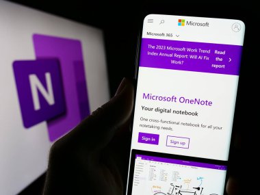 Stuttgart, Almanya - 09-21-2023: Not alma yazılımı web sitesi Microsoft OneNote ile birlikte logo önünde cep telefonu tutan kişi. Telefon ekranının merkezine odaklan.