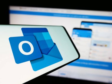 Stuttgart, Almanya - 09-21-2023: Şirketin web sitesi önünde üzerinde Microsoft Outlook 'un logosu bulunan cep telefonu. Telefon ekranının merkez soluna odaklan.