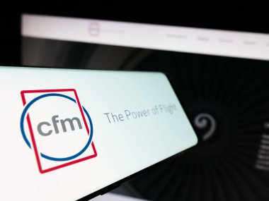 Stuttgart, Almanya - 09-22-2023: Uçak motoru şirketi CFM International logosu olan akıllı telefon iş dünyasının web sitesinin önünde ekranda. Telefon ekranının merkez soluna odaklan.