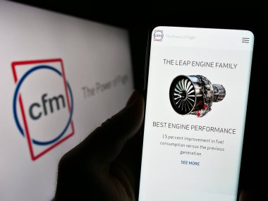Stuttgart, Almanya - 09-22-2023: Uçak motoru şirketi CFM International 'ın web sayfası olan cep telefonu logonun önünde ekranda. Telefon ekranının merkezine odaklan.
