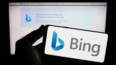 Stuttgart, Almanya - 09-22-2023: Web arama motoru logosu olan akıllı telefonu web sitesinin önünde ekranda tutan kişi. Telefon ekranına odaklan.