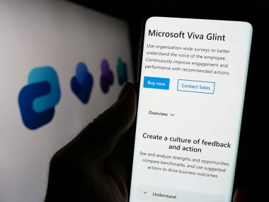 Stuttgart, Almanya - 09-22-2023: Çalışan deneyim platformu web sayfası ile akıllı telefon sahibi kişi ekranda logolu Microsoft Viva. Telefon ekranının merkezine odaklan.