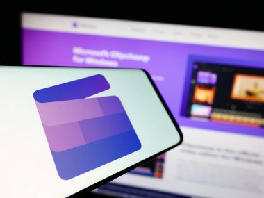 Stuttgart, Germany - 09-22-2023: Smartphone with logo of video editing software Clipchamp (Microsoft) on screen in front of website. Focus on center-left of phone display. clipart