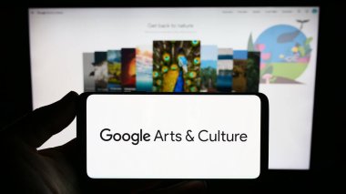 Stuttgart, Almanya - 09-23-2023: İnternet sitesinin önündeki ekranda Google Sanat ve Kültür platformunun logosuna sahip akıllı telefon sahibi kişi. Telefon ekranına odaklan.