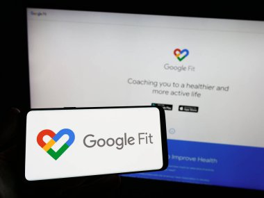Stuttgart, Almanya - 09-23-2023: İnternet sitesinin önündeki ekranda sağlık izleme yazılımı Google Fit logosuna sahip akıllı telefon sahibi kişi. Telefon ekranına odaklan.