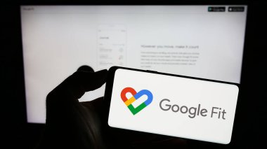 Stuttgart, Almanya - 09-23-2023: Sağlık izleme yazılımı logosu olan cep telefonu sahibi kişi Google Fit, şirketin web sayfasının önünde ekranda. Telefon ekranına odaklan.