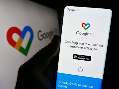 Stuttgart, Almanya - 09-23-2023: Logonun önündeki ekranda sağlık izleme yazılımı Google Fit 'in web sayfası bulunan cep telefonu sahibi. Telefon ekranının merkezine odaklan.