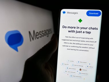 Stuttgart, Almanya - 09-23-2023: Logonun önündeki ekranda Google Mesajları uygulaması web sitesi bulunan cep telefonu sahibi kişi. Telefon ekranının merkezine odaklan.